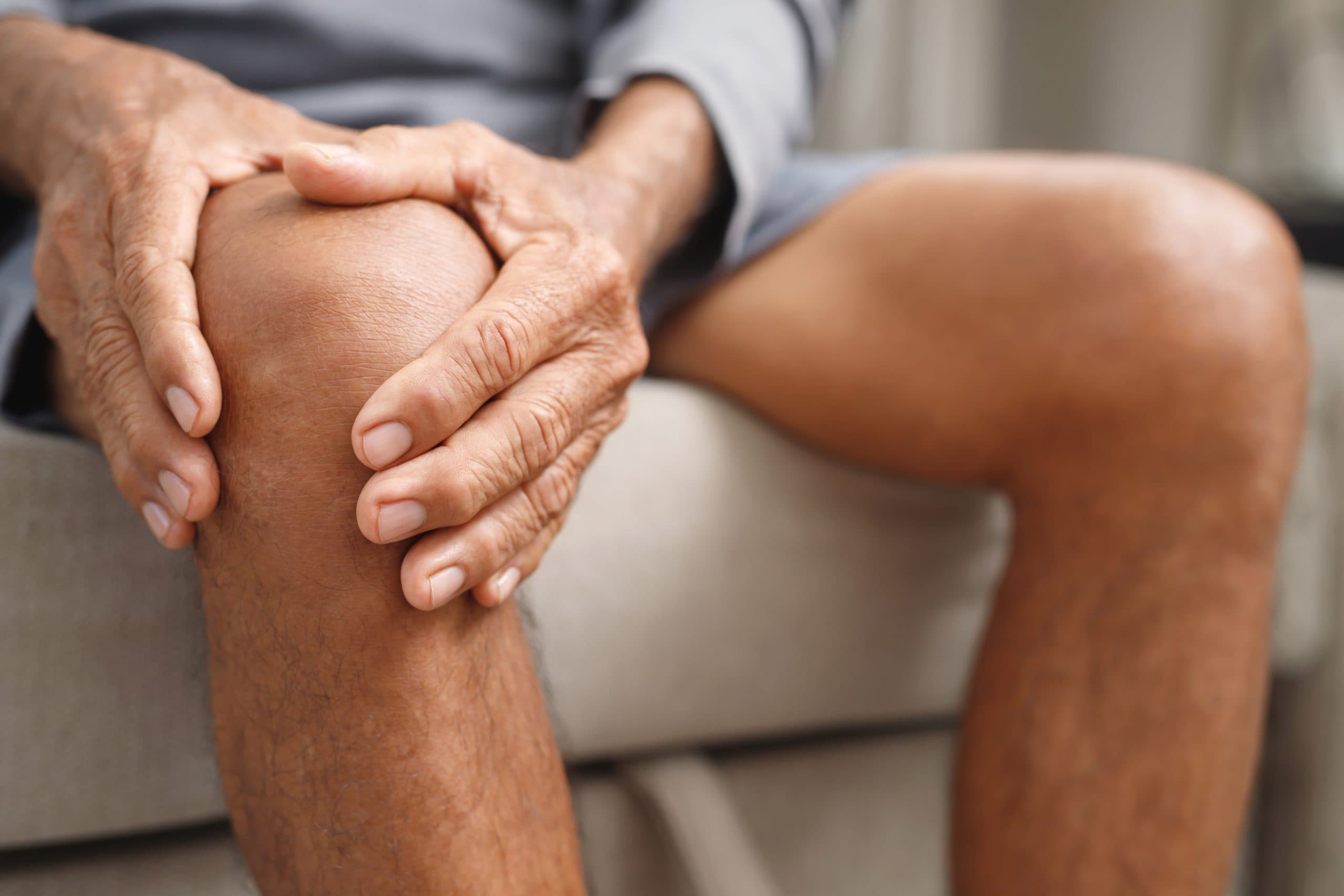 Consultant seated in clinic beside knee model
